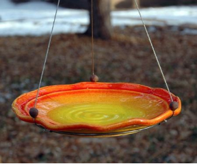 Weather-proof stoneware makes this hanging bird bath useful as a bird feeder in winter.